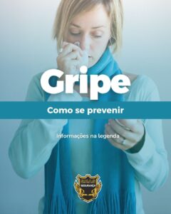 Fotografia de uma mulher loira de olhos fechados, usando um cachecol azul e um casaco verde claro, segurando um lenço de papel próximo ao nariz, indicando estar resfriada. Sobreposta à imagem, há uma faixa horizontal azul-escura com o título principal em letras brancas grandes: "Gripe". Logo abaixo, em letras menores, lê-se: "Como se prevenir" e a frase "Informações na legenda". Na parte inferior central, há o logotipo de uma empresa com um escudo dourado e preto e asas, onde está escrito "S.M.A.S SEGURANÇA"
