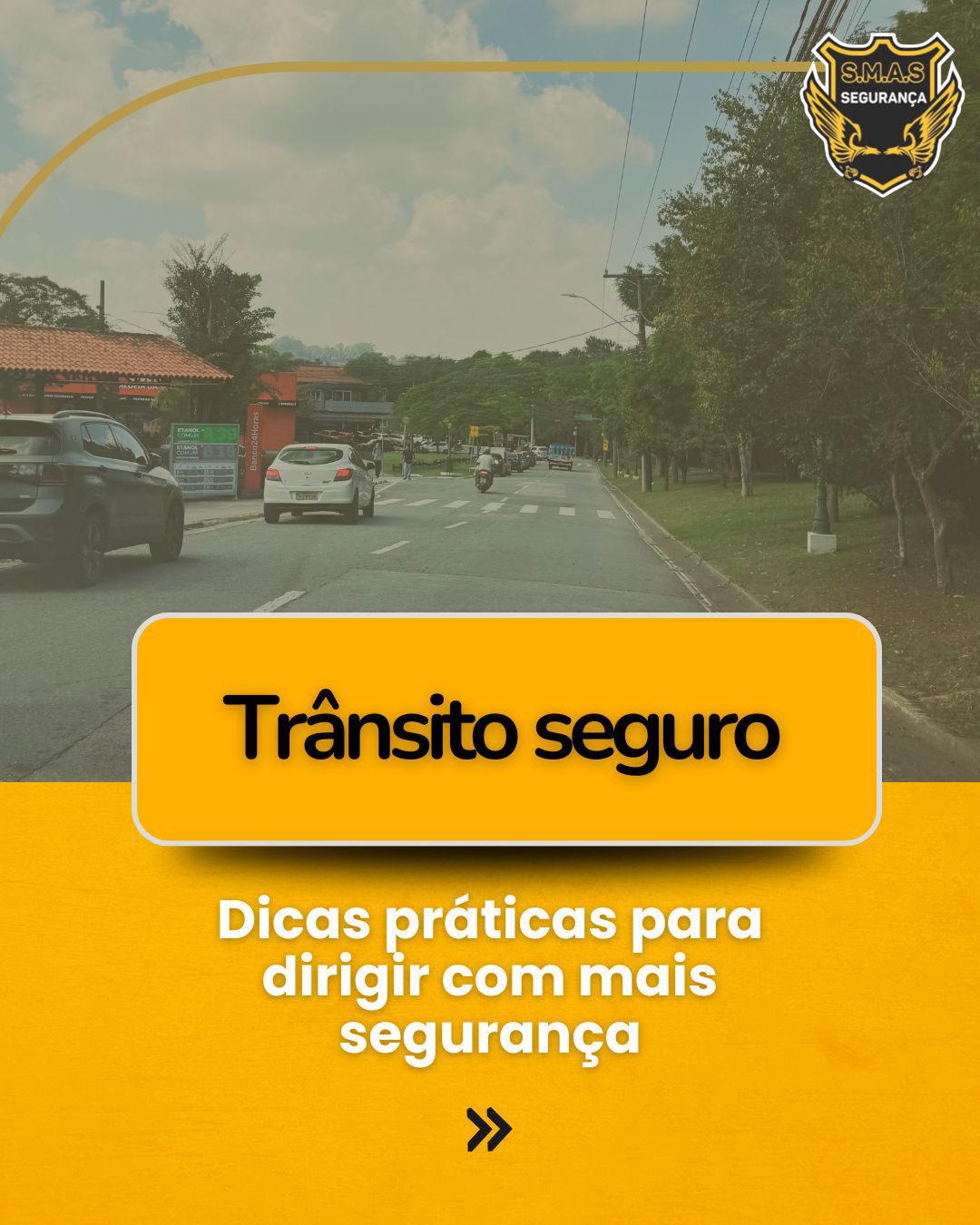 Cartaz digital com o título "Trânsito Seguro" em letras pretas dentro de um retângulo amarelo centralizado. Abaixo, o subtítulo diz: "Dicas práticas para dirigir com mais segurança". O fundo mostra a perspectiva de um motorista em uma via arborizada com carros e uma moto à frente. No canto superior direito, há o logotipo da "S.M.A.S Segurança". O rodapé é amarelo vibrante com um ícone de seta dupla indicando continuidade.